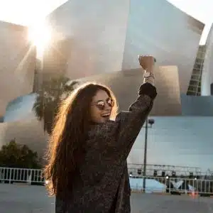 woman walking towards grey building